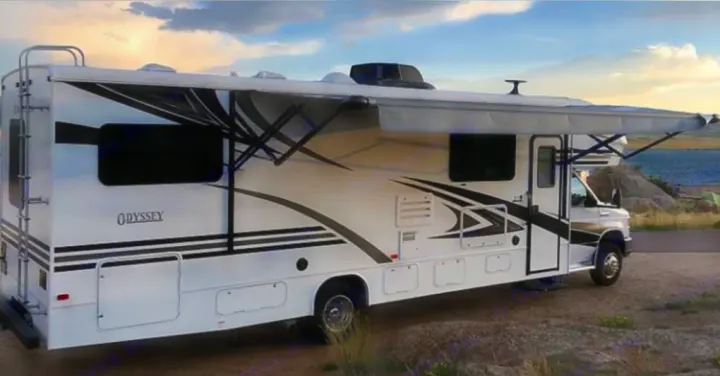 Explore with an RV rental! White Jayco Odyssey motorhome with extended awning, parked in a. Entegra Coach odyssey 2022