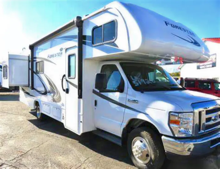 A white Class C RV, a Forester model, is parked outdoors with an extended awning, typical of an rv rental.. Forest River Forester 2020