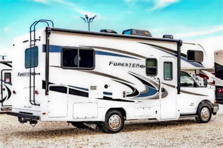 White Forest River Forester RV, ideal for an rv rental adventure. Parked on gravel under blue sky.. Forest River Forester 2020