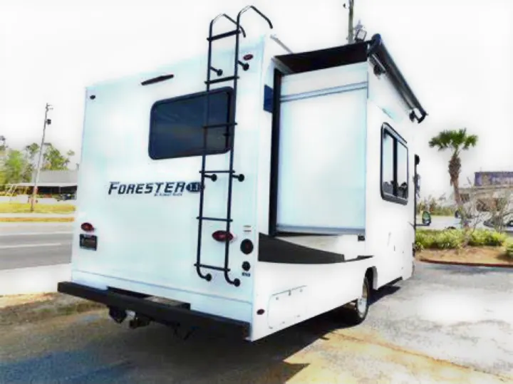 White Forester RV rental with an extended slide-out, rear ladder, and hitch, ready for travel.. Forest River Forester 2020