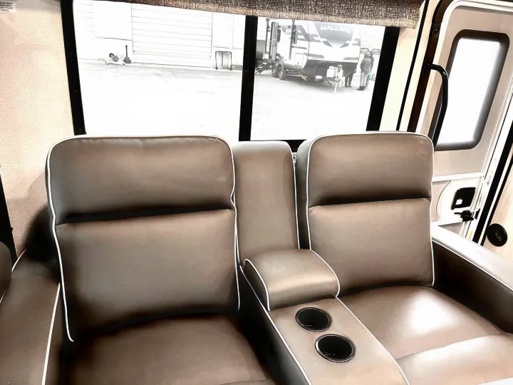 Relax in this RV rental's comfortable recliners with cup holders, looking out at other RVs.. Forest River Forester 2020
