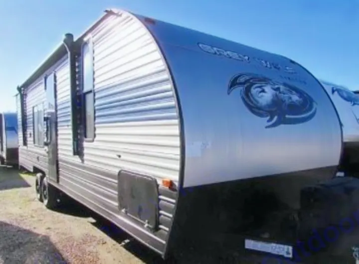 Close-up of a sleek, silver Grey Wolf travel trailer, an excellent RV rental option for your next road trip.. Forest River Cherokee 2021