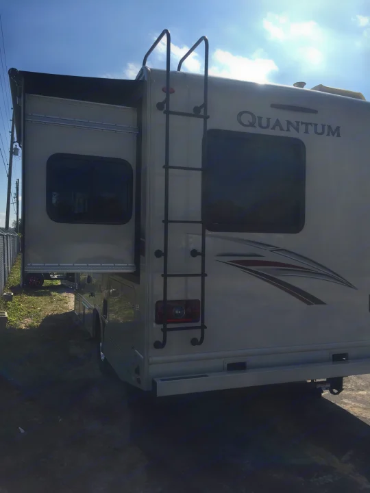 A large Quantum RV, featuring an extended slide-out and rear ladder. Consider this for your next rv rental experience.. Thor Motor Coach Quantum GR 22 2020