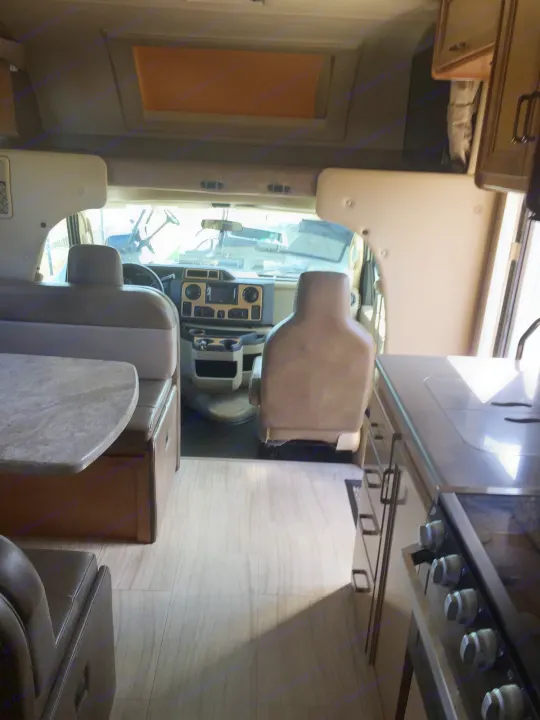 Spacious RV rental interior: well-appointed kitchen, cozy dinette, and driver's cockpit area visible.. Thor Motor Coach Quantum GR 22 2020