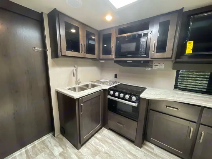 Galley w/deep stainless sink, gas stove top, gas oven and microwave.. Grand Design Transcend 2022