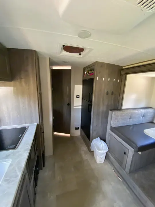 Inside an RV rental, discover a functional kitchen with appliances, comfortable dinette seating, and a well-ventilated bathroom area.. Coachmen Apex Nano 194 BHS 2021