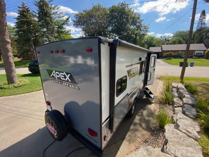 This grey and white Apex Nano Off-Grid RV rental is parked in a sunny driveway, ready for adventure.. Coachmen Apex Nano 194 BHS 2021