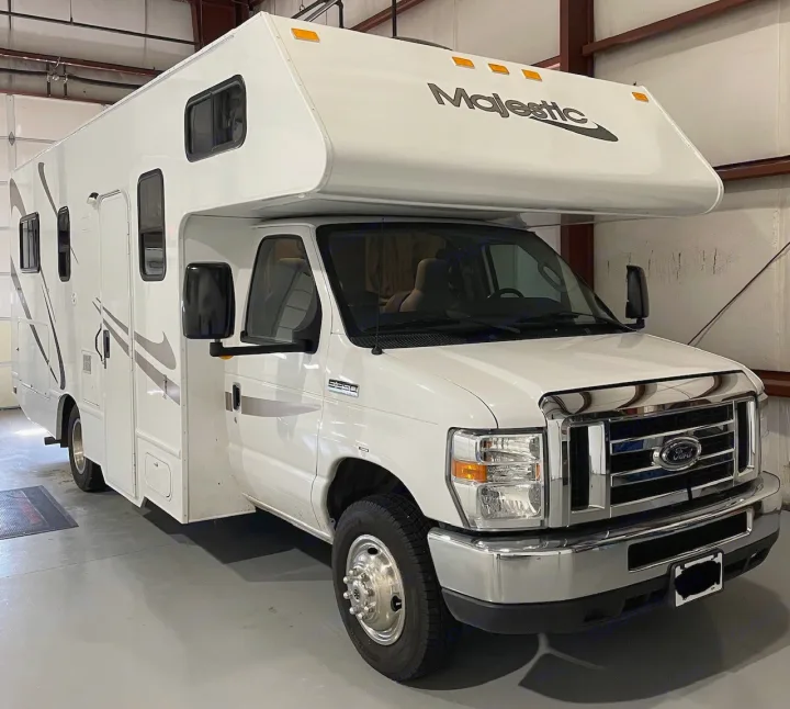 Clean white Ford Majestic Class C RV rental motorhome, parked indoors and ready for your next adventure.. Thor Motor Coach Four Winds Majestic 2018