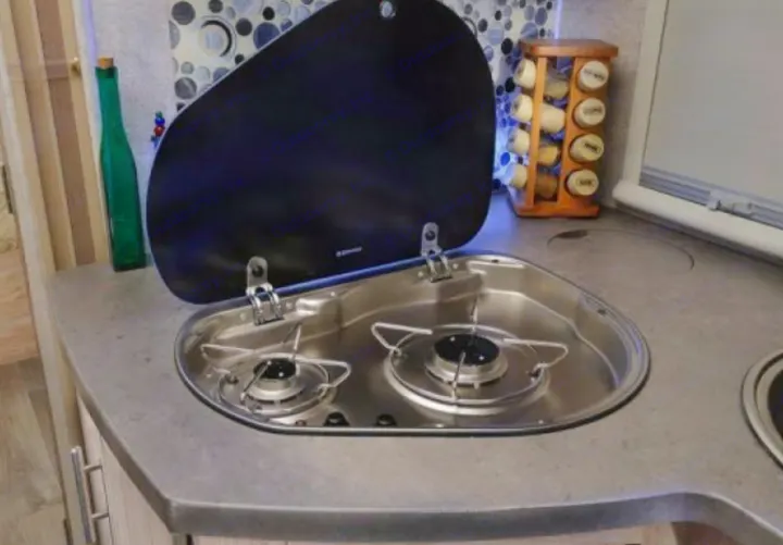 Experience an rv rental with a compact kitchen: dual gas burners, integrated sink, and countertop with a spice rack.. Forest River Sunseeker 2017