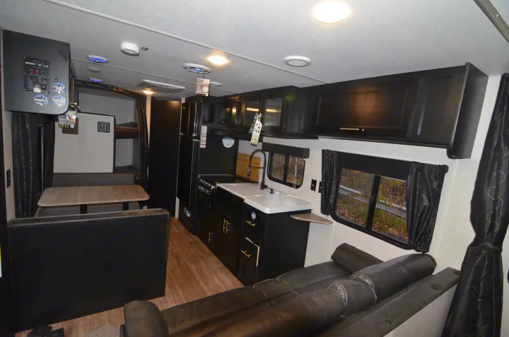 Explore this RV rental's well-equipped interior: a full kitchen, dining booth, comfy sofa, and bunk beds. Adventure awaits!. Forest River Cherokee 2021