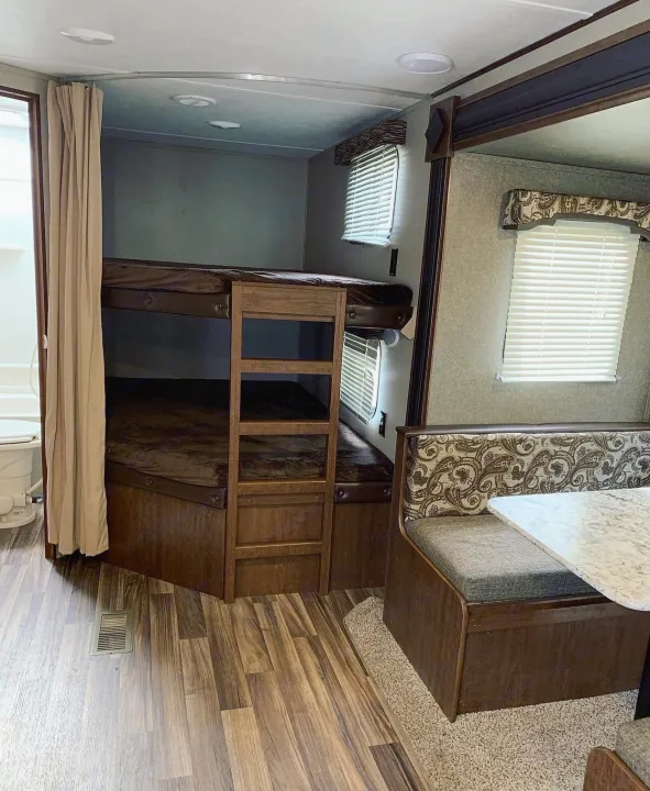 RV rental interior: bunk beds, dinette, and wood-look flooring.. Keystone Hideout 2018