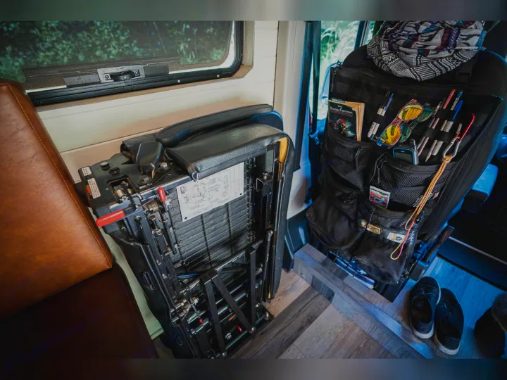 RV rental interior: A gear-filled tactical seat organizer hangs on a swiveled seat; a complex seat base optimizes space.. Dodge promaster 3500 2018