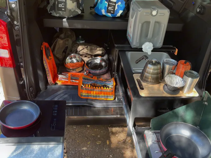 This RV rental's compact mobile kitchen setup, with organized storage, a sink, and cooking appliances, is ready for camping.. Mercedes-Benz Metris 2020