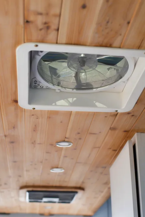 An RV rental's wooden ceiling with a white vent fan and controls, and recessed lighting for optimal airflow & ambiance.. Mercedes-Benz Sprinter 2021
