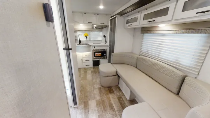 RV rental: Bright, modern interior featuring a compact kitchen, comfy U-shaped sofa, and light wood-look flooring.. Forest River R-Pod 2022