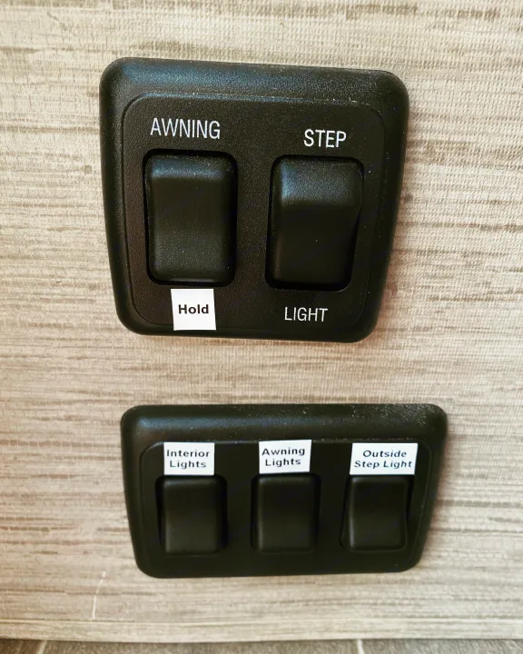 RV rental control panel with switches for awning, step, interior, awning, and outside step lights.. Thor Magnitude 2022