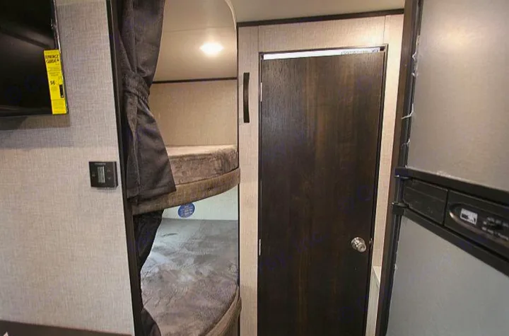 Spacious RV rental interior with bunk beds, TV, and fridge. Ideal for comfortable camper trips.. Jayco Jay Flight 2022