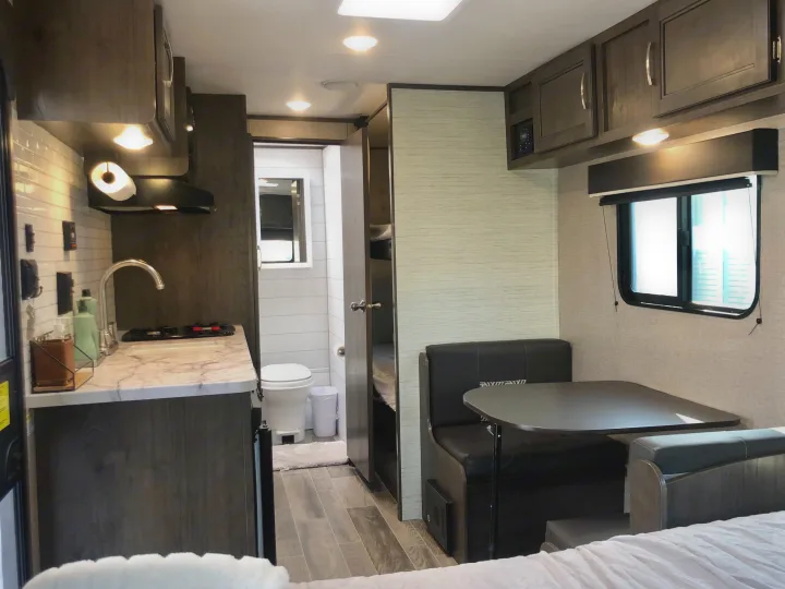 Modern RV rental interior with full kitchen, bathroom, dinette, and bunk beds.. Jayco Jay Flight 2021