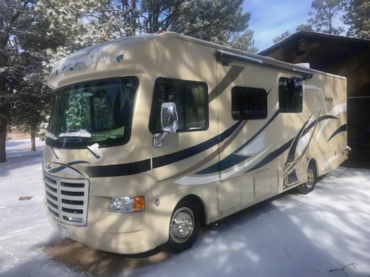 Large beige Class A motorhome for rv rental, parked in snow. Ready for winter travel and scenic adventures.. Other A.C.E 2016