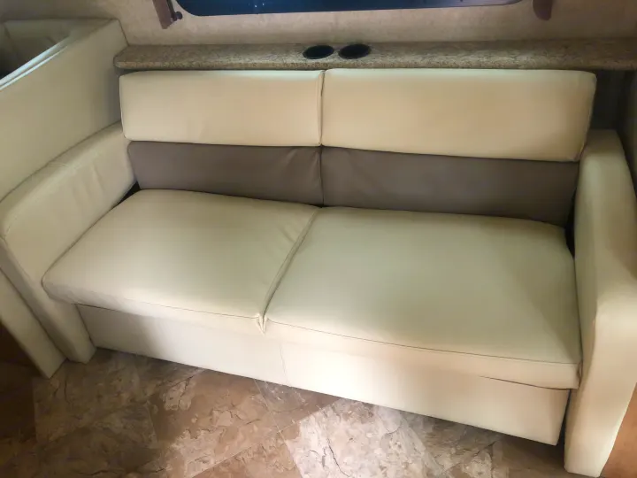 Light-colored, two-tone sofa with cup holders in a clean RV rental interior.. Other A.C.E 2016