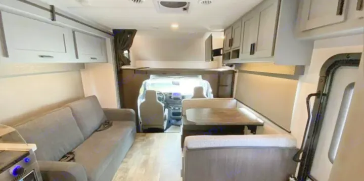 Inside an RV rental: a full view of the living area, featuring a sofa, dinette, and cockpit. Ideal for travel.. Forest River Solera 2022