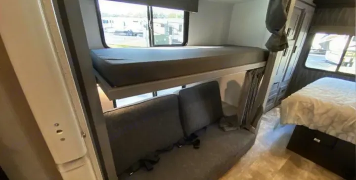 **RV rental** interior: bunk beds, a sofa with seatbelts, master bed, and storage offer comfortable family travel.. Forest River Solera 2022