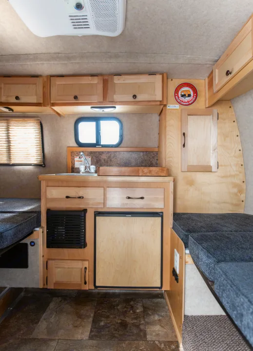 Explore a Bee 2 Gether RV rental's compact interior: kitchen, Dometic fridge, storage, and convertible seating.. Scamp Scamp 2021