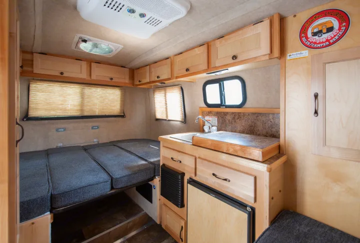 This RV rental's inviting interior features a kitchenette, Dometic fridge, convertible bed, and storage.. Scamp Scamp 2021