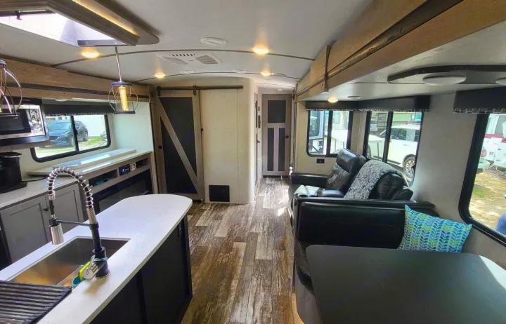 RV rental interior featuring a well-appointed kitchen, comfortable living space with leather seating, and modern decor.. Keystone Outback 2020