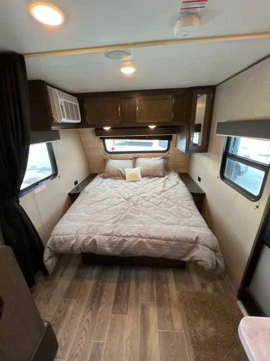 Relax in this cozy RV rental bedroom. Features a comfortable bed, ample storage, AC, and large windows for natural light.. Jayco Jay Flight SLX Baja Edition 2021