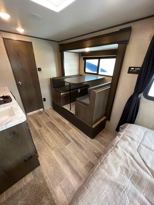 RV rental interior: dinette, kitchen, and bed visible. Modern and clean design for travel.. Jayco Jay Flight SLX Baja Edition 2021