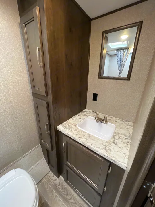 RV rental bathroom: modern vanity, sink, large mirror, and tall storage cabinets.. Jayco Jay Flight SLX Baja Edition 2021