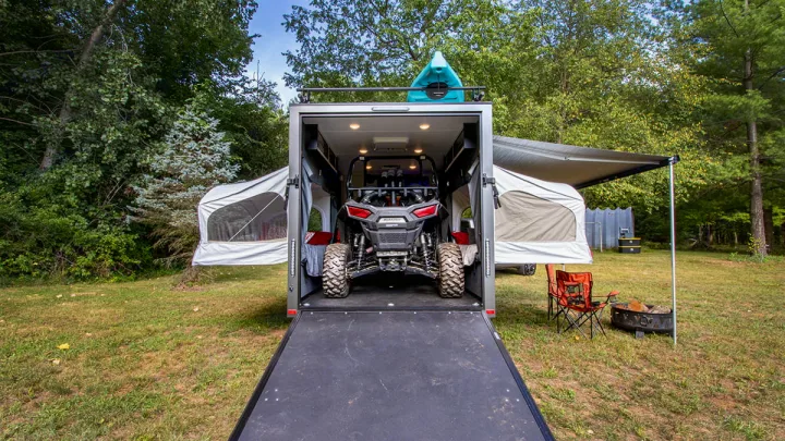 RV rental: This toy hauler opens to reveal a UTV, with a kayak on top and pop-out tents extended, creating a full campsite.. InTech RV Flyer Discover 2021