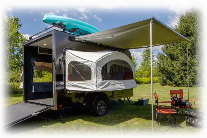 This compact camper, ideal for RV rental, offers a pop-out tent, rooftop kayak, and shaded awning for outdoor camping.. InTech RV Flyer Discover 2021