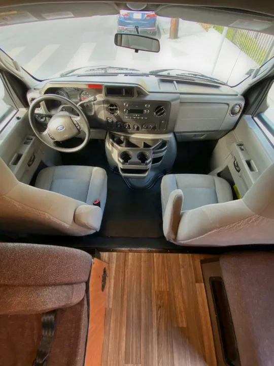 Spacious RV rental front cab: interior view showing dashboard, steering wheel, and driver/passenger seats.. Thor Majestic 2018