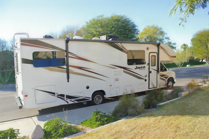 A white Jayco Redhawk RV rental is parked on a sunny day, ready for travel and outdoor adventure.. Jayco Redhawk 2020