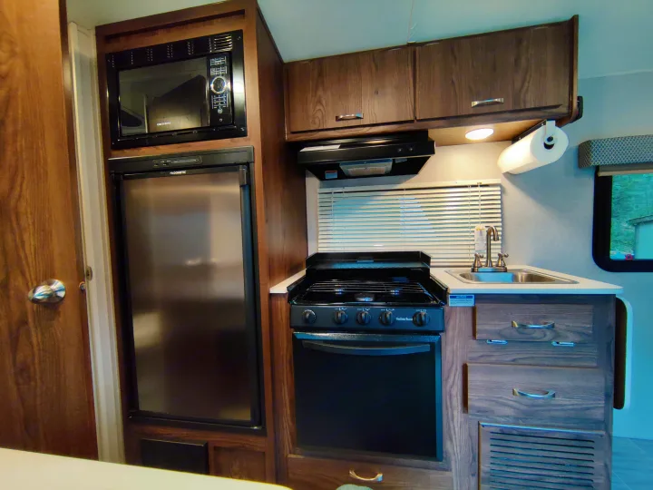 RV rental: fully-equipped kitchen with Greystone microwave, Dometic fridge, Suburban oven/range, sink, and overhead cabinets.. Forest River Geo Pro 2018