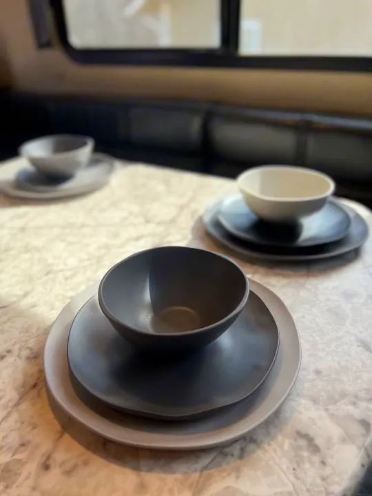 Modern dinnerware sets on a marble-look countertop inside an RV rental. Perfect for your next road trip!. Grand Design Imagine 2018