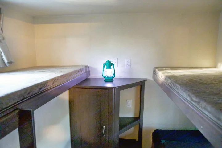 Compact RV rental bunk area with a glowing lantern illuminating comfortable sleeping spaces and convenient outlets.. Forest River Salem 2018