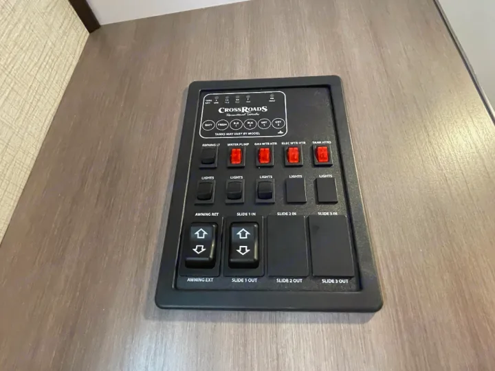 This RV rental control panel for a Crossroads unit features switches for lights, awning, slides, water heaters, and tank levels.. Crossroads Sunset trail 242HB 2022