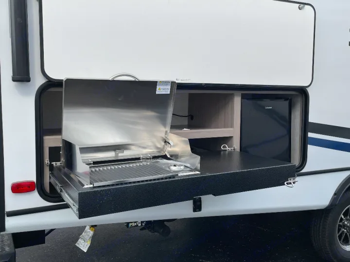 This RV rental features a convenient outdoor kitchen with a pull-out grill and mini-fridge for camping adventures.. Crossroads Sunset trail 242HB 2022