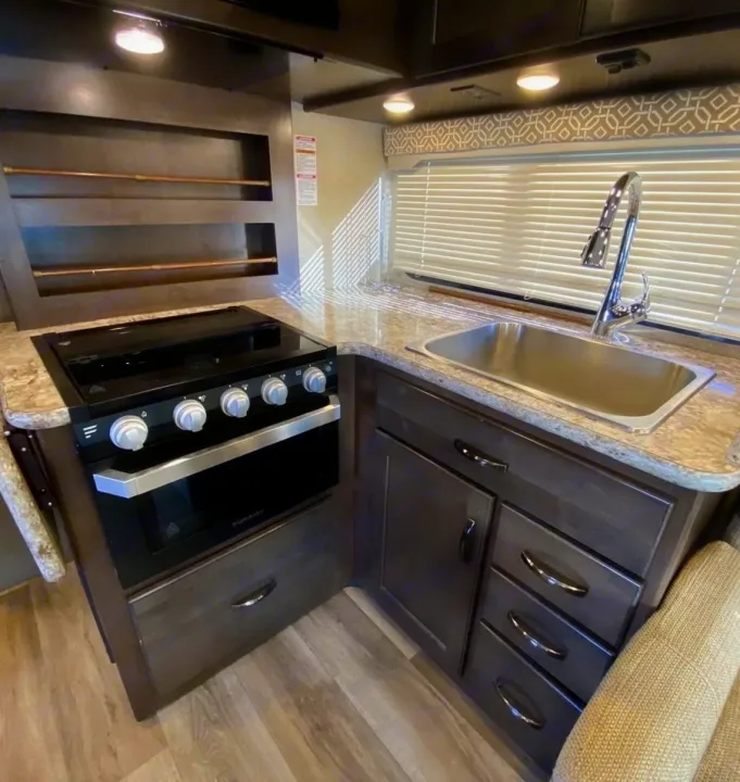 RV rental: Well-equipped compact kitchen with stovetop, oven, sink, and storage cabinets. Ready for your adventure.. Thor Motor Coach Freedom Elite 2019