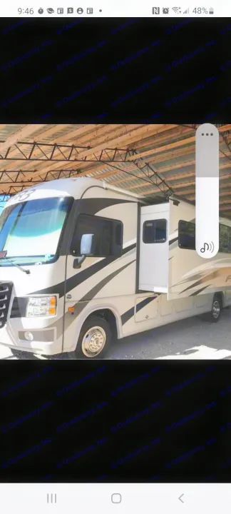 Modern RV rental, light-colored with dark accents, slide-out extended, parked under a sturdy shelter.. Forest River Fr3 2015