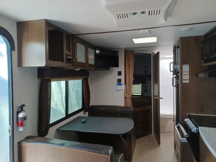 Experience comfort in this RV rental! Features a dinette, kitchen, and glimpses of the bedroom & bathroom areas for your next camper trip.. Keystone RV Passport Express 2019