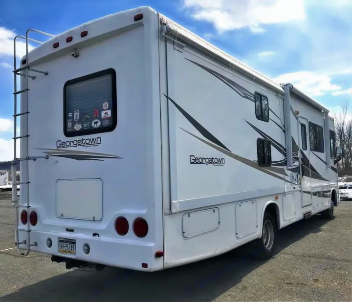 This large white Georgetown RV rental, with a rear ladder & side slide-out, is parked outdoors. Perfect for travel adventures.. Forest River Other 2011