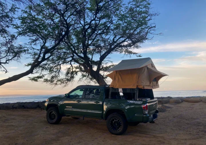 Experience beach camping with this green Toyota Tacoma and rooftop tent. A great RV rental option for your next overlanding trip.. Toyota Tacoma 2021