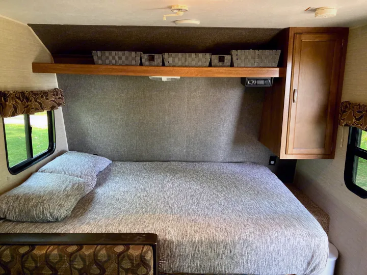 Cozy RV rental bedroom featuring a comfortable bed, overhead storage, and entertainment for your travels.. Keystone RV Summerland Mini 2016