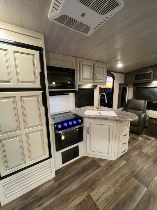 Explore this modern rv rental interior, featuring a fully-equipped kitchen with Dometic, Greystone, and Furrion appliances.. Keystone Cougar Half-Ton 2021