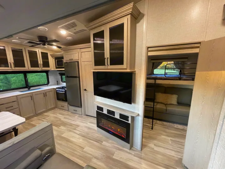 Spacious RV rental interior featuring a modern kitchen, living area with fireplace, and a bunk room with sofa.. Forest River Other 2022