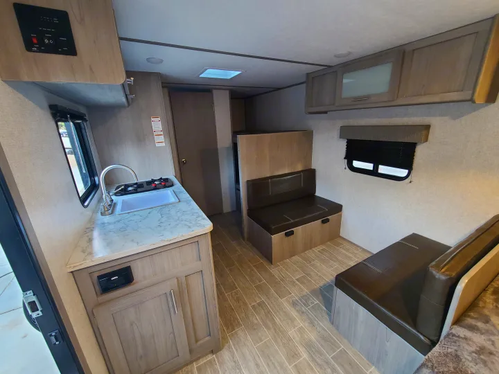 Inside this modern rv rental, featuring a kitchen, dining area, and rear bunk beds for cozy adventures.. Coleman Latern 17b 2022